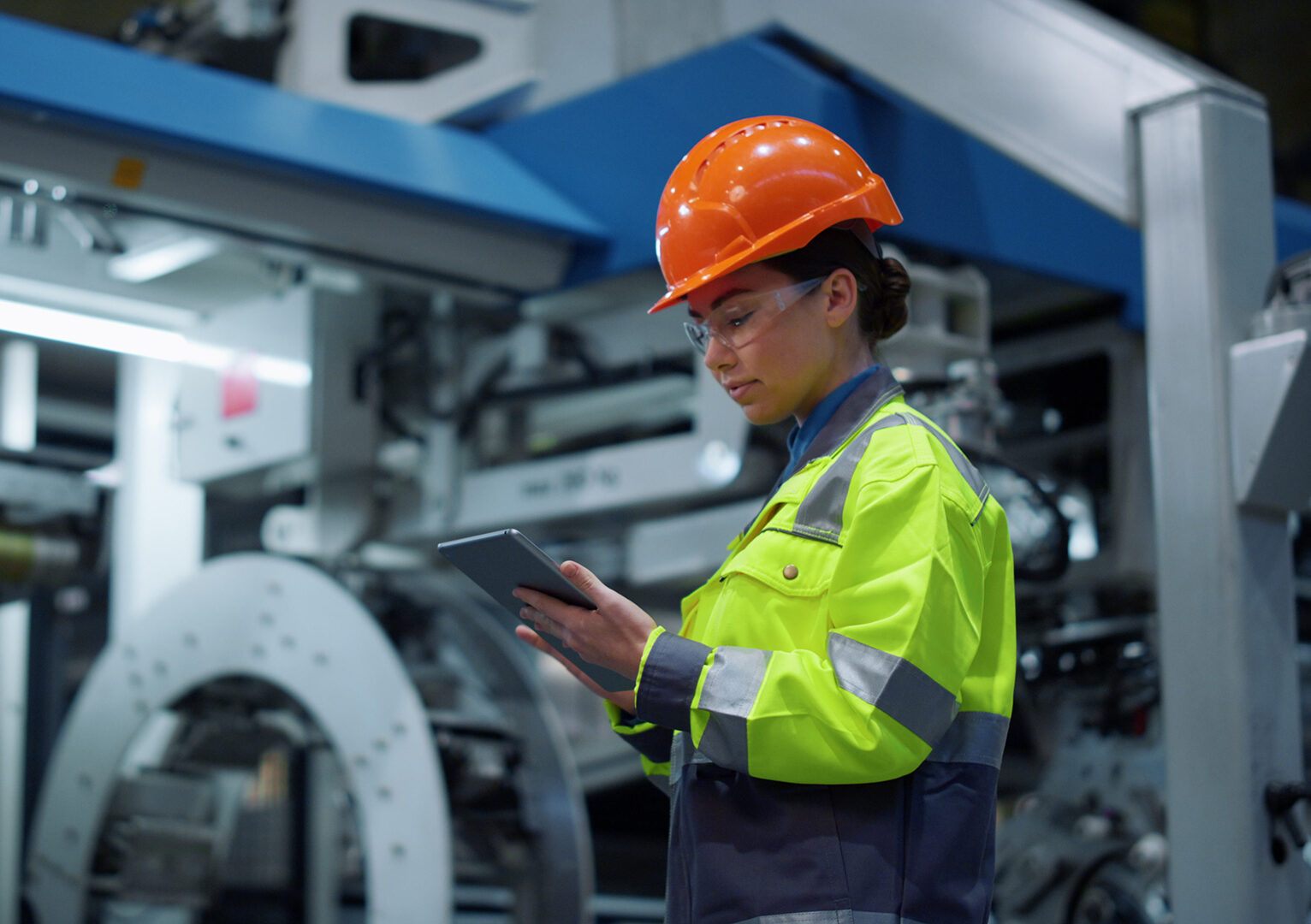 Focused engineer working tablet on modern production factory.