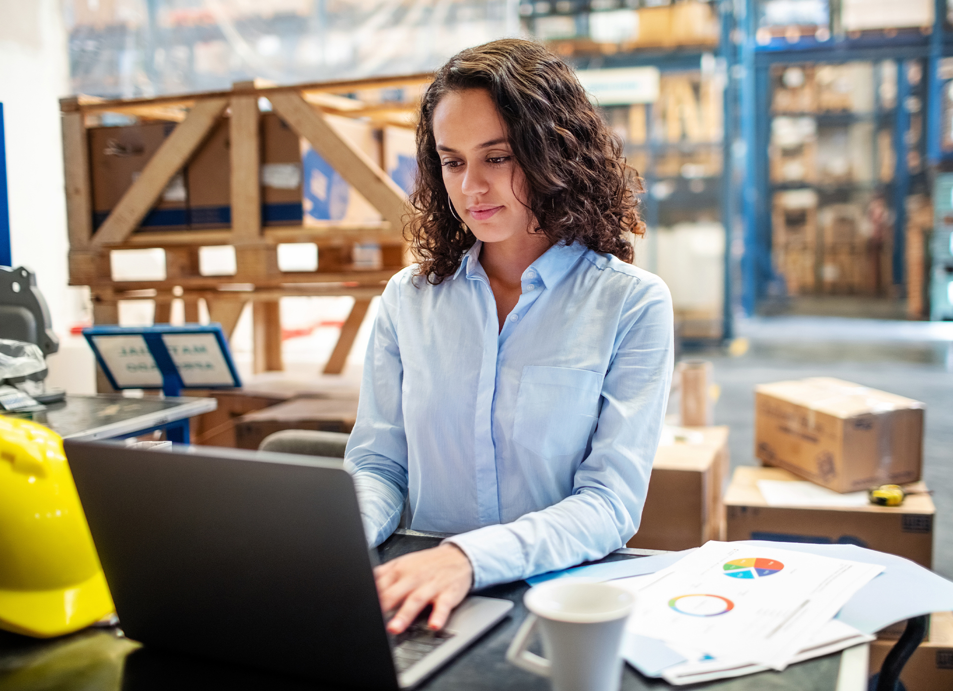 Woman in warehouse using laptop